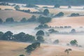 Glorious landscape image of layers of mist rolling over South Downs National Park English countryside during misty Summer sunrise Royalty Free Stock Photo