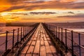 A glorious morning at Blyth beach, with a beautiful sunrise over the old wooden Pier stretching out to the North Sea Royalty Free Stock Photo