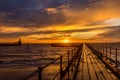 A glorious morning at Blyth beach, with a beautiful sunrise over the old wooden Pier stretching out to the North Sea Royalty Free Stock Photo
