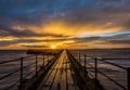 A glorious morning at Blyth beach, with a beautiful sunrise over the old wooden Pier stretching out to the North Sea Royalty Free Stock Photo