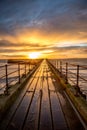 A glorious morning at Blyth beach, with a beautiful sunrise over the old wooden Pier stretching out to the North Sea Royalty Free Stock Photo