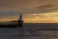 A glorious morning at Blyth beach, with a beautiful sunrise over the old wooden Pier stretching out to the North Sea Royalty Free Stock Photo