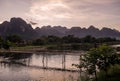 Glorious sunset over the mountains that dominate Vang Vieng overlooking the Nam Song river and the wooden bridge, Laos