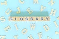 Glossary part of a book concept. Wooden blocks typography word flat lay Royalty Free Stock Photo