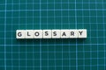 Glossary word made of square letter word on green background.