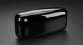A glossy, black, rectangular object with smoothly rounded edges rests on a dark reflective surface. Royalty Free Stock Photo