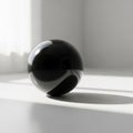A glossy black sphere rests on a smooth, light-colored surface Royalty Free Stock Photo