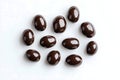 Glossy Dark Chocolate Candies Scattered on White Background Royalty Free Stock Photo
