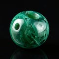 Glossy Green Emerald Gemstone Bead on Black Royalty Free Stock Photo