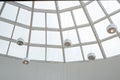 Glossy metal balls under modern white glass roof.