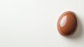 Glossy milk chocolate easter egg resting on pristine white surface, highlighting seasonal confectionery detail and festive Royalty Free Stock Photo