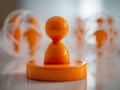 Glossy orange abstract human figure statue with spherical cage structures blurred in background on reflective surface creating Royalty Free Stock Photo