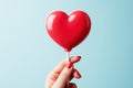 Glossy Red Heart Lollipop in Female Hand