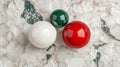 Glossy Red White and Green Spheres on Textured Off White Surface Royalty Free Stock Photo