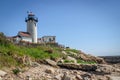 Aged lighthouse over rocks and weeds Royalty Free Stock Photo