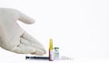 A glove covered human hand indicating Corona Virus Vaccine, injectable medicines and a syringe on white background
