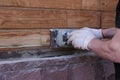 Gloved carpenter uses wood polisher. Cleaning and polishing of wooden surfaces. A man makes repairs at home