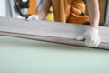 Gloved craftsman holds laminate board indoors closeup