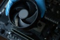 Gloved craftsman installing cooler into video card closeup