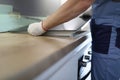 Gloved craftsman installs hob in kitchen closeup