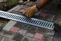 A gloved craftsman lays paving stones in layers. Brick paving slabs for professional use. Laying gray concrete paving slabs in the