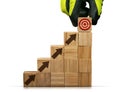 Gloved Hand Arranging Wood Blocks as Step Stair and Target Symbol