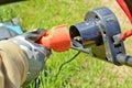 Gloved hand with electric cable and plug connects the lawn mower to the power supply. Royalty Free Stock Photo