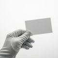 A gloved hand holding a blank white card against a plain background Royalty Free Stock Photo