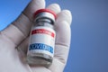 gloved hand holding coronavirus vaccine vial Royalty Free Stock Photo