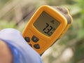 Gloved Hand Holding Infrared Thermometer Over Leaves Royalty Free Stock Photo