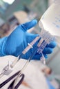 Gloved hand holding intravenous drip in the patient ward Royalty Free Stock Photo