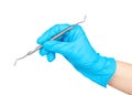 gloved hand holding a metal dental tool trowel two-way, and the