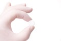 Gloved hand holding small round pill Royalty Free Stock Photo