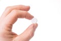 Gloved hand holding small round pill Royalty Free Stock Photo