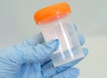 Gloved hand holding specimen bottle Royalty Free Stock Photo