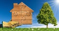 Gloved Hand Holding a Wooden House Made of Puzzle Pieces Royalty Free Stock Photo