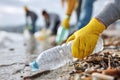Volunteer Collecting Plastic Bottle from Polluted Beach Royalty Free Stock Photo