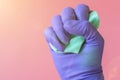 Gloved hand with washcloth on pink background. Rubber gloves and a washcloth for cleaning on a pink background. Set of rubber