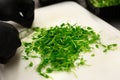 Gloved hands cutting green pea sprouts with knife on white plastic chopping board Royalty Free Stock Photo