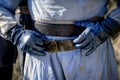 gloved hands fastening a sword belt around waist