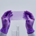 Gloved hands hold sheet of paper over test tube