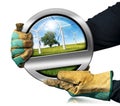 Gloved Hands Holding a Metal Symbol with Wind Turbines