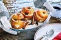 Gloved hands holding a plate of baked apples