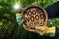 Gloved Hands Holding a Tree Trunk with Text One Hundred Percent Natural Wood