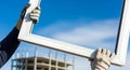 Gloved Hands Holding Window Frame Against Blue Sky At Building Construction Site Royalty Free Stock Photo