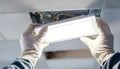 Gloved hands install a ceiling light fixture Royalty Free Stock Photo