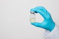 The gloved hands of a nurse dilute the antibiotic with saline. Close-up photo. Step-by-step instruction, step seven