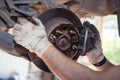 Gloved hands remove the worn rear wheel hub support. Royalty Free Stock Photo