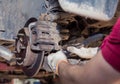 Gloved hands remove the worn rear wheel hub support. Royalty Free Stock Photo