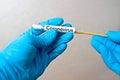 Gloved hands with swab, patient sample collection, sterile sample ready for analysis, viral disease testing COVID-19 pandemic, Royalty Free Stock Photo